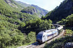 NSB El 18 2243 at the mountain Sjølvskot on the Flåm line. In 1992, freight services were terminated, and due to low ticket prices and high operating costs, the line was nearly closed. In 1998, Flåm Utvikling took over marketing and ticket sale for the line, prices were heavily increased and El 17 locomotives were introduced. The trains remain operated by the Norwegian State Railways (NSB), while the line itself is owned and operated by the Norwegian National Rail Administration.
Date: 13 July 2018.