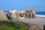 Perurail 756 & 752 arrive to Mollendo with their train of empty tank cars passing by a little castle on the cliff.