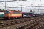 A train with automotives is hauled by 240 118 through Bratislava hl.st.