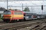 A train with automotives is hauled by 240 118 through Bratislava hl.st.