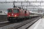 In the pouring rain, SBB 11200 hauls a quasi-retro EuroCity into Erstfeld on 19 September 2021.