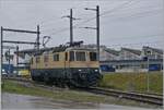 The IRSI/IGE  Rheingold  Re 4/4 II 11387 (Re 421 387-2) coming from Morges leaves the line to Genève in Gland and runs over an industrial track towards the gravel plant to pick up its train to