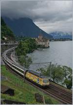 A SBB Re 460 with an IR to Brig near the Castle of Chillon.