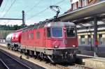 On 5 June 2014 Re 6/6 11613 with two cement wagons speeds through Spiez.