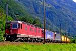 Three Re 6/6 locos, 11671 leading, haul a postal train through Erstfeld on 15 September 2011.