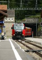The RhB Ge 4/4 III 648 is coming out of the Albula Tunnel and arriving with his RE to Chur in Preda.