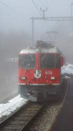 The RhB Ge 4/4 II N°616 is coming out of the fog by Litzirüti.