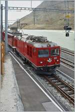 The RhB Gem 4/4 801 and a RhB ABe 4/4 II with a Bernina local service on the way to St Moritz by his stop in Ospizio Bernina.