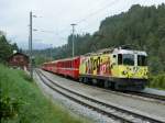 The  Little Red  in yellow: Ge 4/4 II with the RE Disentis - Chur - Scuol is leaving in Valendas-Sagogn.