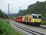 The  Little Red  in yellow: Ge 4/4 II with the RE Disentis - Chur - Scuol is leaving in Valendas-Sagogn.
