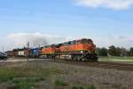 The Dash 9 of the BNSF (964 and 5450) and the CEFX engine 3423 with a mixed freight train in Sealy (Texas).